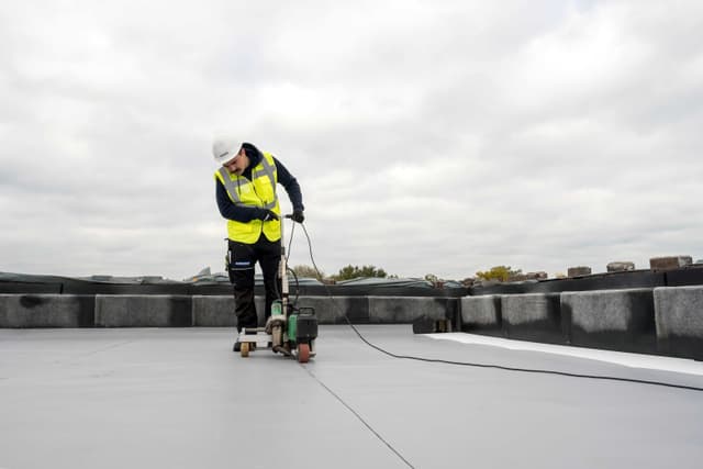 Roofer adding a tpo membrane to a roof